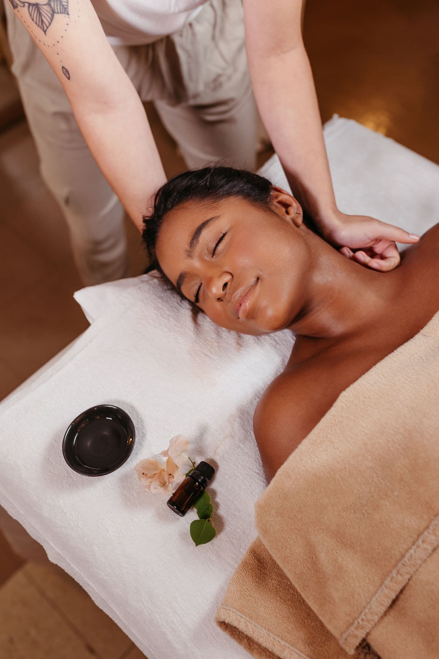 Mujer recibiendo un masaje relajante a domicilio con aceites esenciales
